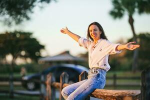 Portrait of happy young woman outdoor in the park at sunset photo