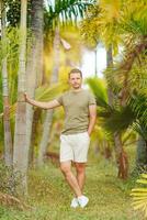 a man standing in front of palm trees photo