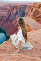 Happy girl on the edge of the cliff at Horseshoe Band Canyon in Page, Arizona. Adventure and tourism concept. Beautiful nature in USA photo