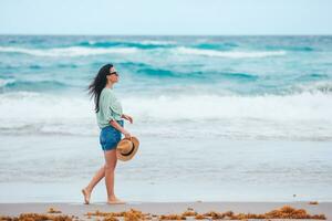 Young happy woman on the beach enjoys her summer vacation photo