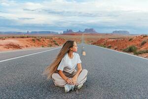 Happy girl on the famous road to Monument Valley in Utah. Amazing view of the Monument valley. photo