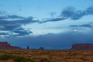 ver de Monumento Valle en Utah en luz de la luna. puesta de sol a Monumento Valle con Luna en el cielo foto