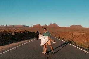 Happy couple on the famous road to Monument Valley in Utah in their trip on Canyon in USA. Scenic highway in Monument Valley Tribal Park in Utah. photo