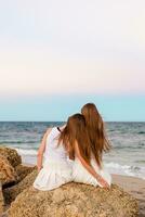 Adorable teen girls in white on the seashore during beach summer vacation with amazing sky on background photo