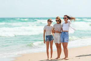 Adorable little girls and young mother on tropical white beach photo