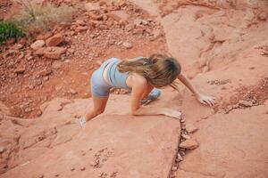 Young girl climbs in red mountains on trail photo
