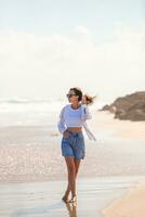 joven feliz en la playa disfruta de sus vacaciones de verano. la chica está feliz y tranquila en su estancia en la playa foto