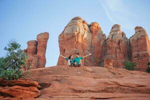 Young hiker woman on the edge of a cliff at Cathedral Rock in Sedona, Arizona. View from Scenic Cathedral Rock in Sedona with blue sky in Arizona photo