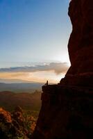 joven caminante mujer en el borde de un acantilado a catedral rock en sedona, Arizona. ver desde escénico catedral rock en sedona con azul cielo en Arizona foto