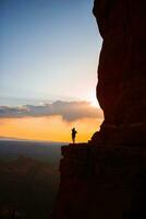 joven caminante mujer en el borde de un acantilado a catedral rock en sedona, Arizona. ver desde escénico catedral rock en sedona con azul cielo en Arizona foto