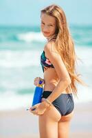 Happy young girl with sunblock on tropical beach vacation photo