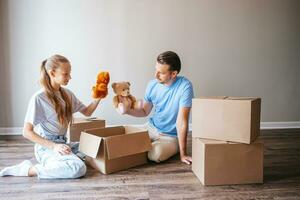 la familia de papá y su hija adolescente se divierten en su nuevo hogar con cajas de cartón. familia disfruta de su día de mudanza foto