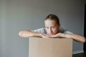 Happy girl moving in new house with cardboard boxes photo