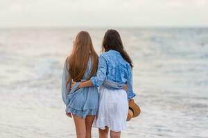 Beautiful mother and daughter at Carribean beach enjoying summer vacation photo