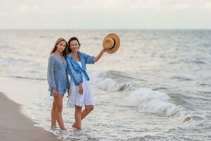 Beautiful mother and daughter at Carribean beach enjoying summer vacation photo