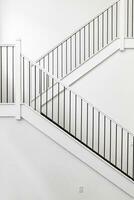 Modern white wooden staircase in new house interior with big windows photo