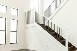 Modern white wooden staircase in new house interior with big windows photo