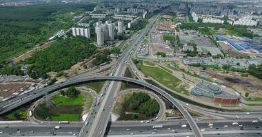 un aéreo ver de un enorme y ocupado la carretera unión en el medio de el verde paisaje urbano video