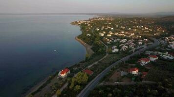 flygande över trikorfo strand kustlinje med stugor och grön höglandet, grekland video