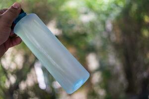 Man hand holding water bottle. photo