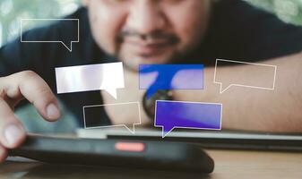 Happy man using smartphone text messages in cellphone screen with abstract hologram speech bubbles. photo