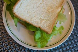 Homemade sandwich with fresh vegetables on dish photo