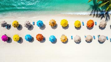 Beautiful tropical beach with colorful beach umbrellas, white sand, palm trees and turquoise ocean. The perfect paradise for your holiday photo