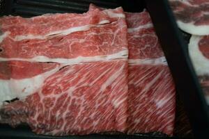 un alto calidad diapositiva carne de res, wagyu carne de vaca y estofado para shabu shabu foto