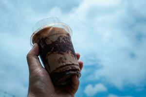 Hand holding iced mocha with showing the texture and refreshing look of the drink photo