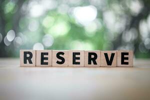 Reserve word is written on wood block. Reserved text on wood table. photo