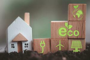 Miniature house with wood block with icons of eco house. photo