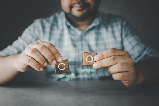 Smiling man showing a wood block with an empty check box between very good or excellent photo