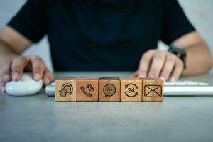 Customer service and contact us icon on the cube wood block with computer keyboard and staff photo