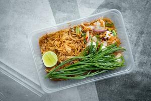 Fresh oysters in spicy salad topping with raw acacia, slice lemon and fried onions in box. photo