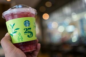 Bangkok, Thailand - August 22, 2023 Green paper cup sleeve of  Starbucks Thailand celebrates 25 years photo