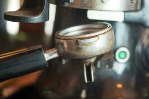 Grinded coffee beans into a metal filter holder in a coffee machine. photo