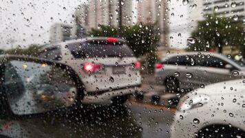 un carros ventana es cubierto en gotas de lluvia como eso viajes abajo un ocupado ruta foto