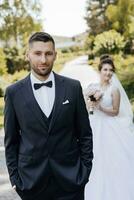 Happy bride and groom after wedding ceremony. Stylish groom. Adult groom. The groom in the foreground photo