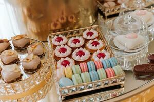 Candy bar. Table with sweets, candies, dessert. cakes and berries in the candy bar. Candy bar with delicious mini cakes, selective focus photo