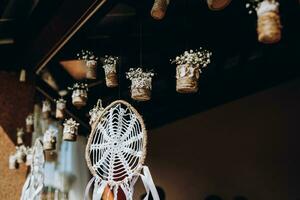 Original wedding floral decoration in the form of mini-vases and bouquets of flowers hanging from the ceiling photo