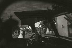 Wedding black and white photo poster. Creative photo idea of wedding photography in reflection. Bride and groom through the car window