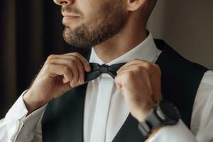 el elegante novio vestidos, prepara para el Boda ceremonia. el del novio Mañana. empresario usa un chaqueta, masculino manos de cerca, novio consiguiendo Listo en el Mañana antes de Boda ceremonia foto