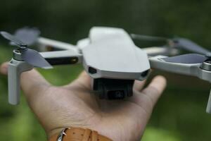 Drone launch. Man holds a drone in his hand lifting it up.  Man pilot Launches quadcopter drone from hand to sky flight, Launching the drone from hands selective focus. photo