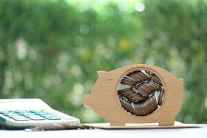 Piggy bank and stack of coins money on natural green background, Save money for prepare in future and pension retirement concept photo