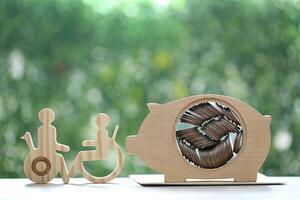 Man on wheelchair and piggy bank on natural green background,Save money for prepare in future and handicapped person concept photo