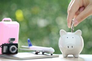 Saving planning for Travel budget of holiday concept, piggy bank and airplane on passport with natural green background photo
