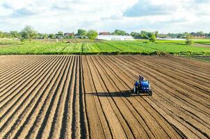 Kherson oblast, Ukraine - May 28, 2020 A farmer cultivates the soil on the site. Milling soil, crushing before cutting rows. Farming, agriculture. Plowing field. Loosening surface, land cultivation. photo