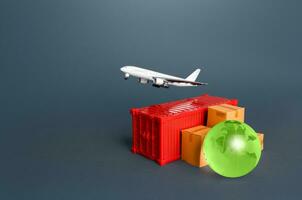 Cargo plane over a container with boxes and a globe. Services of express delivery and transportation of goods by plane. Business and commerce, import export of products. World trade and logistics. photo