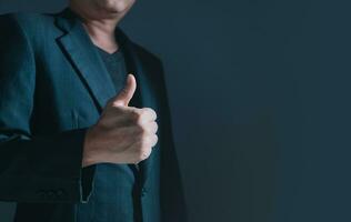 Portrait of businessman in suit standing thumbs up, half body and not showing face. photo