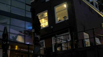 View from moving on the river boat of the buildings with lighting windows, Amsterdam, Netherlands video